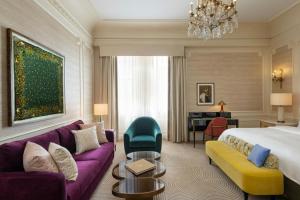 a hotel room with a king bed and a purple couch at The St. Regis New York in New York +108 photos