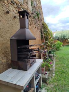 a grill sitting on a wooden bench next to a wall at Ca l'Àvia Remei in Castelló d'Empúries