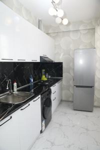 a white kitchen with a sink and a refrigerator at SunRise in Masazır