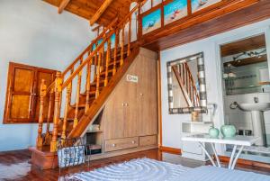 a living room with a wooden staircase in a house at Nikolakis, Seafront- Harbor view in Symi