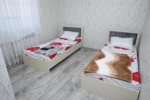 two twin beds in a room with white walls at SunRise in Masazır