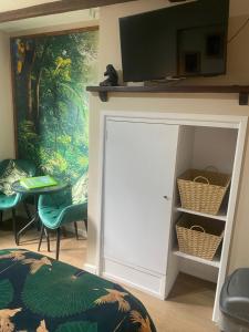 a room with a white door and a tv on a wall at Jungle Lodge in Rustington