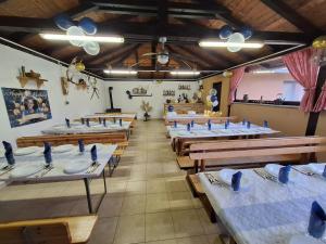 a row of tables in a restaurant with white tables at Kuća za odmor San in Lonja