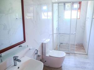 a bathroom with a shower and a toilet and a sink at Ella, Nine Glow Resort in Ella