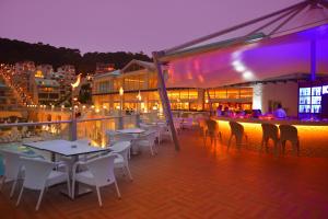 a rooftop deck with tables and chairs at night at Orka Sunlife Resort Hotel and Aquapark in Oludeniz