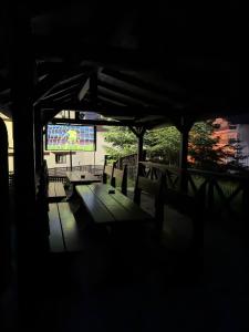 a dark room with a table and benches and a screen at Ideal Predeal in Predeal