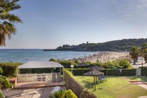 a view of a beach with a gazebo and people at Mora Beach in Tarragona