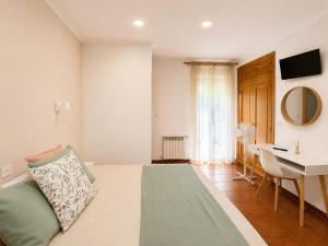 a bedroom with a bed and a table and a desk at Hostal Bellas in Ávila
