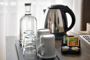 a counter with a coffee maker and a bottle of wine at Hotel Harmony in Prague