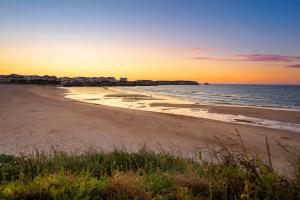 a view of a beach at sunset at Kampaoh Peniche in Peniche