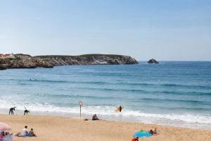 a group of people on a beach near the ocean at Kampaoh Peniche in Peniche