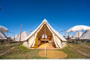 a tent with tables and umbrellas in a field at Kampaoh Peniche in Peniche +35 photos