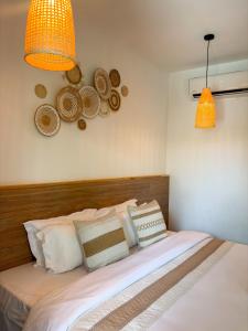 a bedroom with a bed with pillows and two lights at Amaria Maldives in Finolhus
