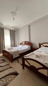 a bedroom with two beds and a window at Casa Vlora in Vlorë