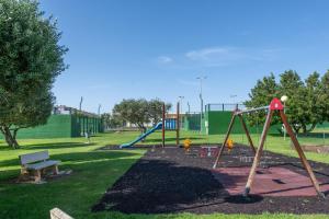 a park with a playground with a swing at Apartment In Golf Mar Resort in San Jorge