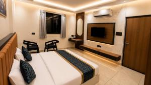 a hotel room with a bed and a flat screen tv at Hotel Shakuntla Palace - 400 Meters away from Vishnu Pad Temple 7 mins walk in Gaya
