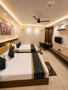 a hotel room with two beds and a flat screen tv at Hotel Shakuntla Palace - 400 Meters away from Vishnu Pad Temple 7 mins walk in Gaya