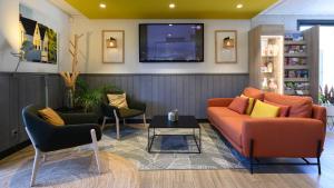 a living room with a couch and two chairs and a tv at Campanile NATURE - Bollene in Bollène