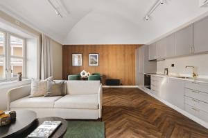 a living room with a white couch and a kitchen at St Elisabeth Hotel & Spa in Tromsø