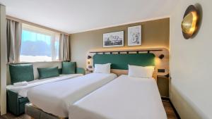 a hotel room with two beds and a window at Campanile NATURE - Bollene in Bollène