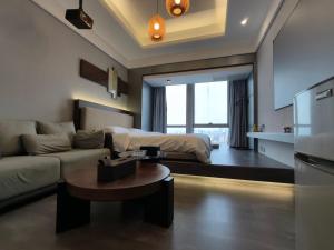 a living room with a couch and a bed at High Clouds Hotel Apartment in Guangzhou