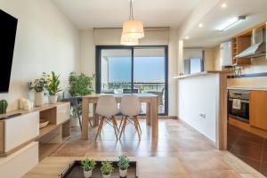 a kitchen with a table and chairs and a large window at Apartment In Golf Mar Resort in San Jorge