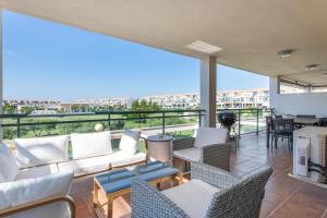 a balcony with white furniture and a view of a city at Apartment In Golf Mar Resort in San Jorge