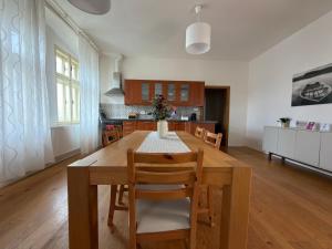 a kitchen with a wooden table and a dining room at Apartmány u komína in Terezín