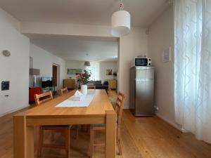 a kitchen and dining room with a table and a refrigerator at Apartmány u komína in Terezín +41 photos