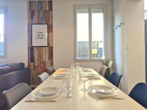 a long table with plates and glasses on it at Vilnius - Confort familial in Reims +12 photos