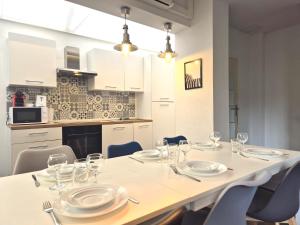 a table with plates and glasses on it in a kitchen at Vilnius - Confort familial in Reims