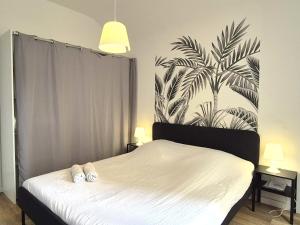 a bedroom with a bed with two white towels on it at Vilnius - Confort familial in Reims