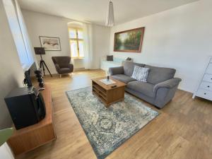 a living room with a couch and a tv at Apartmány u komína in Terezín