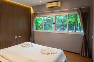 a bedroom with a bed and a large window at The Opium Chiang Mai in Chiang Mai +131 photos