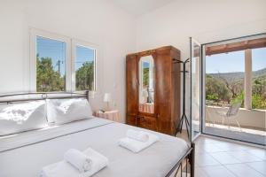 a bedroom with a large bed with two towels at Vasso Galati House in Vaia