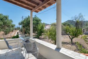 a patio with a table and chairs on a balcony at Vasso Galati House in Vaia