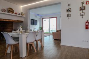 a dining room and living room with a table and chairs at Casa dos Manos in Barbacena
