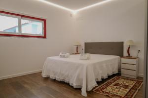 a white room with a bed with white sheets and a window at Casa dos Manos in Barbacena +27 photos
