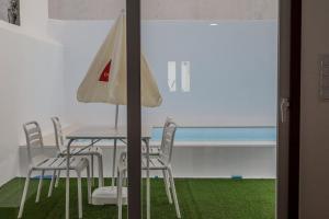 a table with chairs and an umbrella next to the ocean at Casa dos Manos in Barbacena