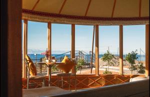 a room with a large window with a view of the ocean at Casablanca Yurts in Kaji-Say