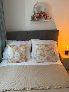 a bed with two pillows and a mirror on the wall at Sara Apartament in Turek
