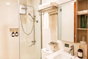 a bathroom with a shower and a sink at Starhomes Hotel & Cafe in Tarlac