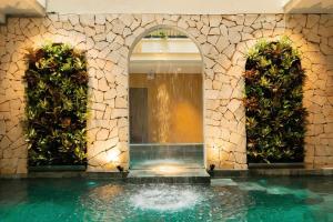 a building with a fountain in a swimming pool at Amsphere Homestay & Restaurant in Hanoi