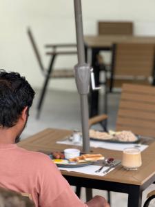 a man sitting at a table with a plate of food at Amaria Maldives in Finolhus