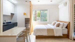 a white bedroom with a bed and a kitchen at Pocheon Skygaram Pension in Pocheon