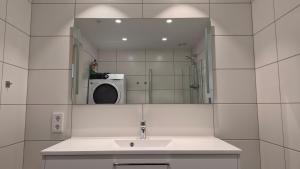 a bathroom with a sink and a mirror and a washing machine at Seabreeze Suite in Arendal +89 photos