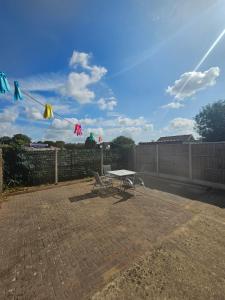 a picnic table and a bench on a patio at Spacious House with Parking and pool table in Kirton