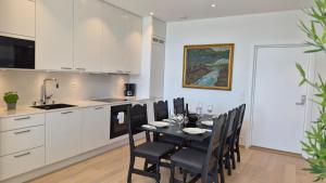a kitchen with a dining room table and chairs at Seabreeze Suite in Arendal