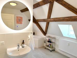 a bathroom with a white sink and a mirror at HyggeLiving - 120qm - Boxspringbetten - 55" Smart TV - Küche - Parkplatz - bis 8 Pers - BESTLAGE in Wernigerode +31 photos