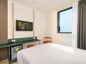 a bedroom with a bed and a tv and a window at B&B HOTEL Catania Bellini in Catania +1 photo